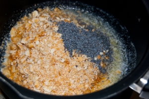 Crushed Ritz Cracker, poppy seeds, and melted butter in a pot.